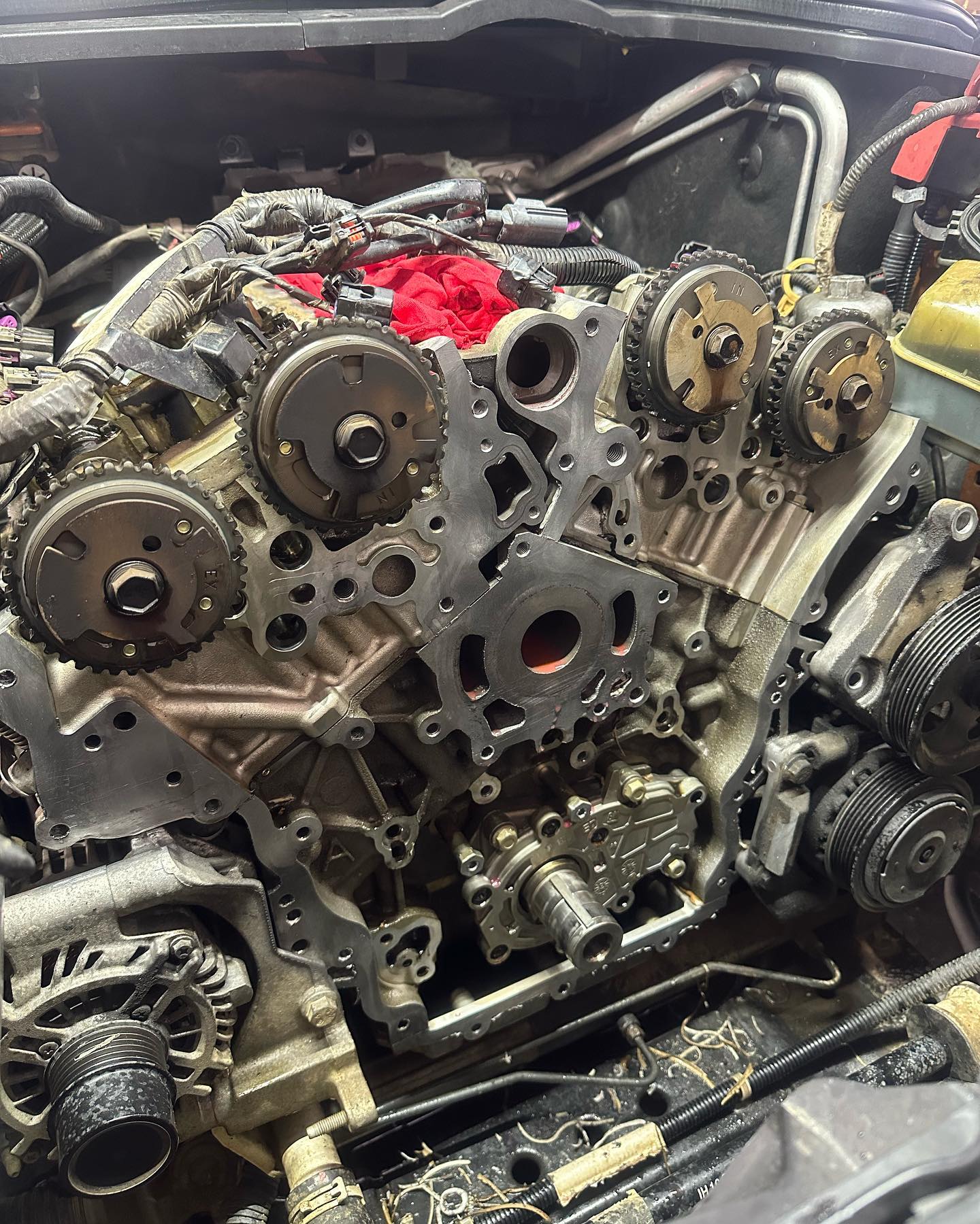 V6 engine with the front cover removed, cam gears and timing chain exposed on the bench