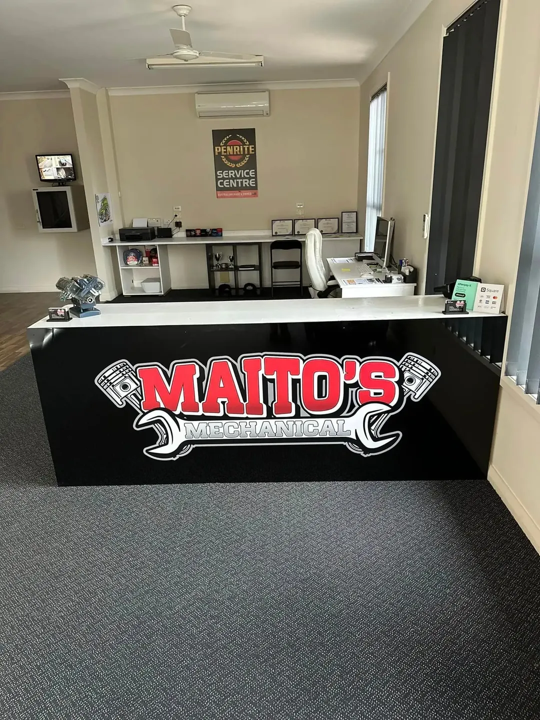 The front counter at Maito’s Mechanical with the workshop logo and the Penrite Service Centre sign behind